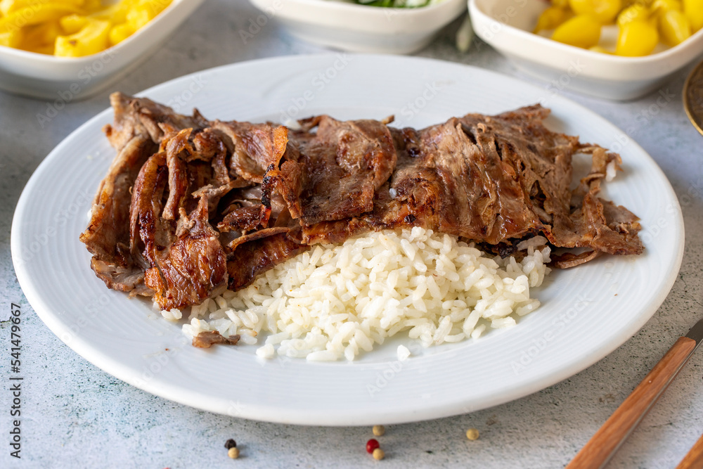 Meat doner with rice on gray background. Traditional flavors. Doner kebab made from beef and lamb. close up Meat doner with rice on gray background. Traditional flavors. Doner kebab made from beef and lamb. close up