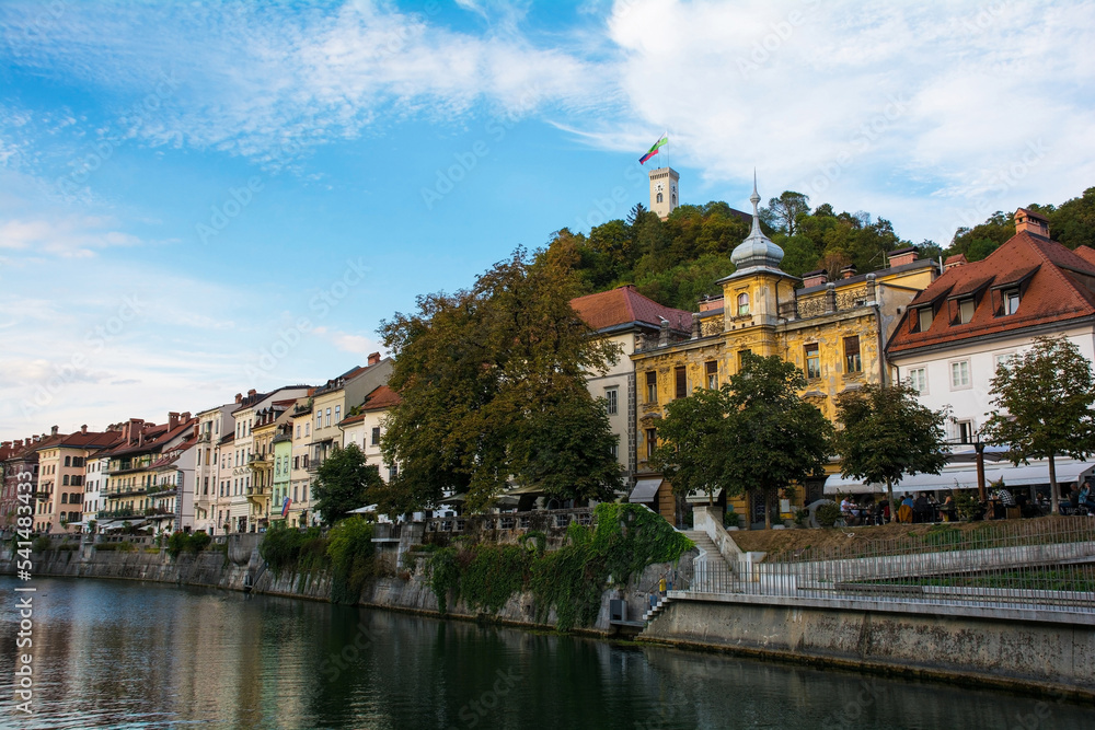 Historic buildings on the waterfront of the Ljubljanici River in central Ljubljana, Slovenia. The castle tower is seen on Castle Hill on the background

