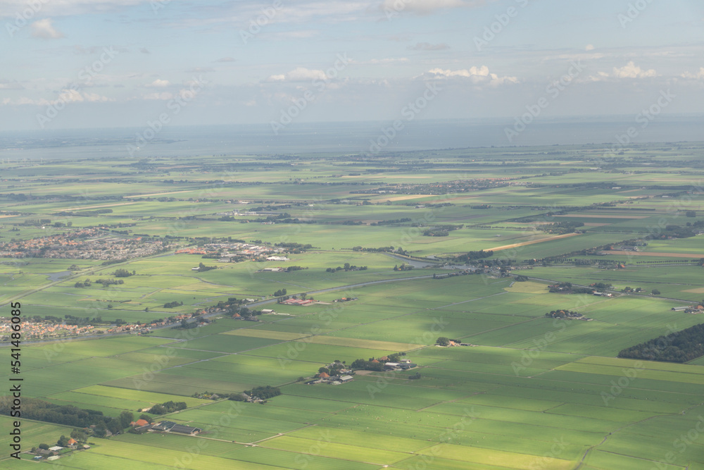 Beautiful aerial shot of Amsterdam green countryside viewed for an airplane in sunny blue day