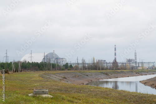 Chernobyl nuclear plant with metal dome over destroyed 4th reactor and famous white and red fireplace 