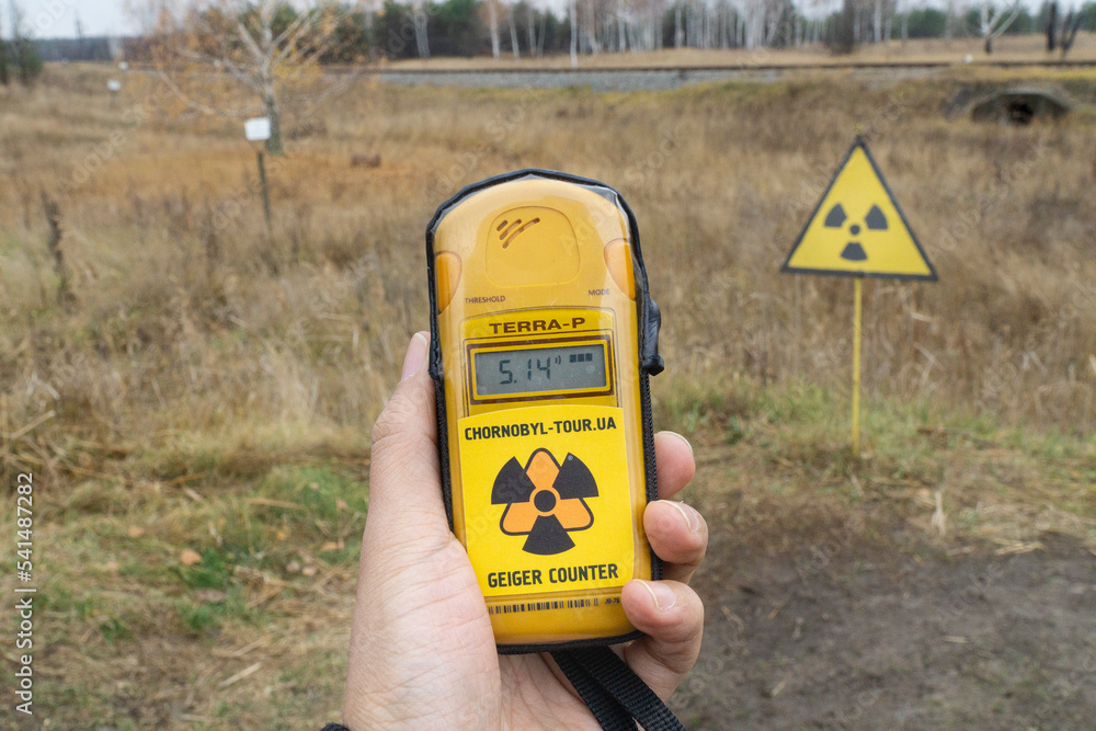 Close up to a geiger counter with radiation levels and a radioactive