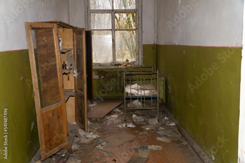 Destroyed wooden furniture and rusty kid bed inside abandonated room at chernobyl kinder garden radioactive disaster exclusion zone photo