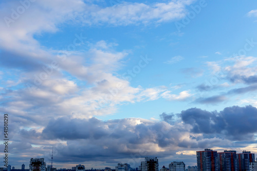 Fluffy white clouds in the blue sky above the city
