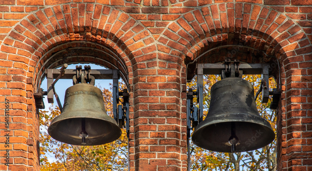 Obraz premium General view and architectural details of the brick belfry built in 1875 and the Catholic Church of the Immaculate Conception of the Blessed Virgin Mary in Ceranów in Mazovia, Poland.