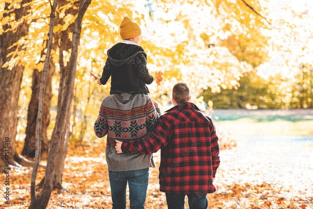 Happy two man couple with adopted child on autumn season Happy two man couple with adopted child on autumn season