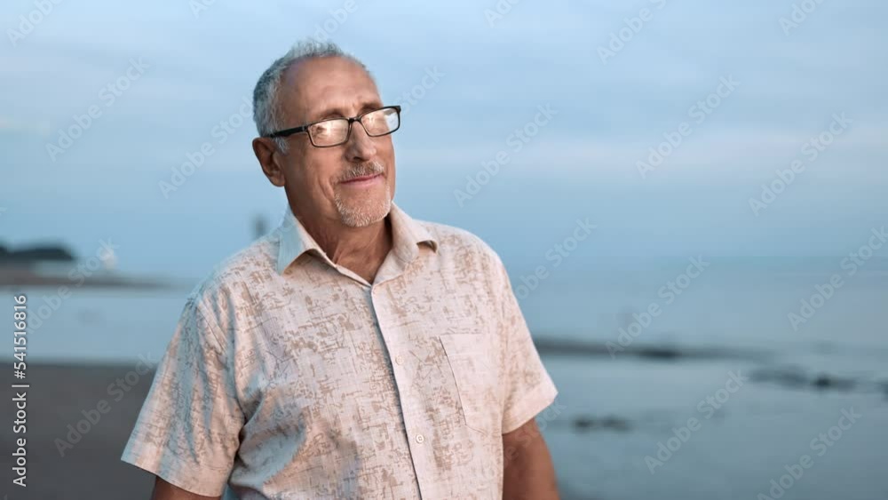 Smiling grandfather tourist walking at sunset sunrise beach sea coast summer tropical resort Smiling grandfather tourist walking at sunset sunrise beach sea coast summer tropical resort