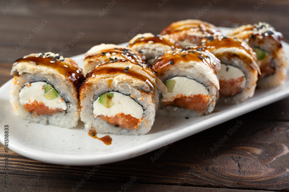 Delicious sushi roll topped with smoked eel and sesame seed. Sushi roll with avocado and crab meat. sushi dish. Delicious sushi restaurant menu Delicious sushi roll topped with smoked eel and sesame seed. Sushi roll with avocado and crab meat. sushi dish. Delicious sushi restaurant menu