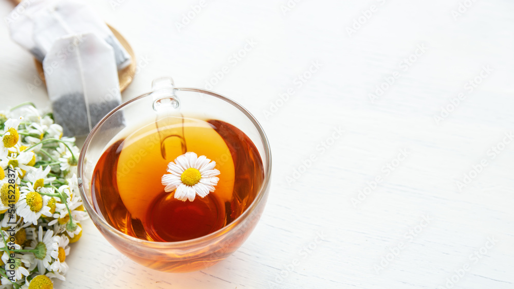 cup of herbal chamomile tea with fresh daisy flowers on wooden background. doctor treatment and prevention of immune concept, medicine - folk, alternative, complementary, traditional medicine cup of herbal chamomile tea with fresh daisy flowers on wooden background. doctor treatment and prevention of immune concept, medicine - folk, alternative, complementary, traditional medicine