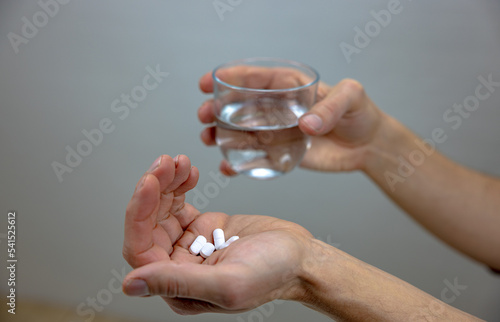 A photo showing a glass with water and pills. Painkillers, Antidepressants. Addicted. Social problem. Healthcare. 