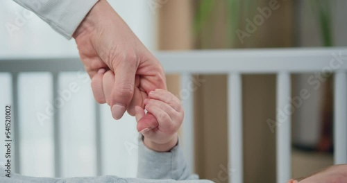 Close-up of hand of mother and infant at children room background. Concept of motherly love, new life and newborn baby