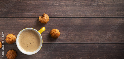 Horizontal banner with coffee with place for text. Aromatic coffee with pastries on a dark wooden background.