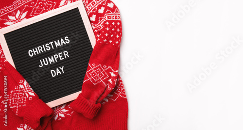 Red Christmas sweater and letter board with words Christmas jumper day.
