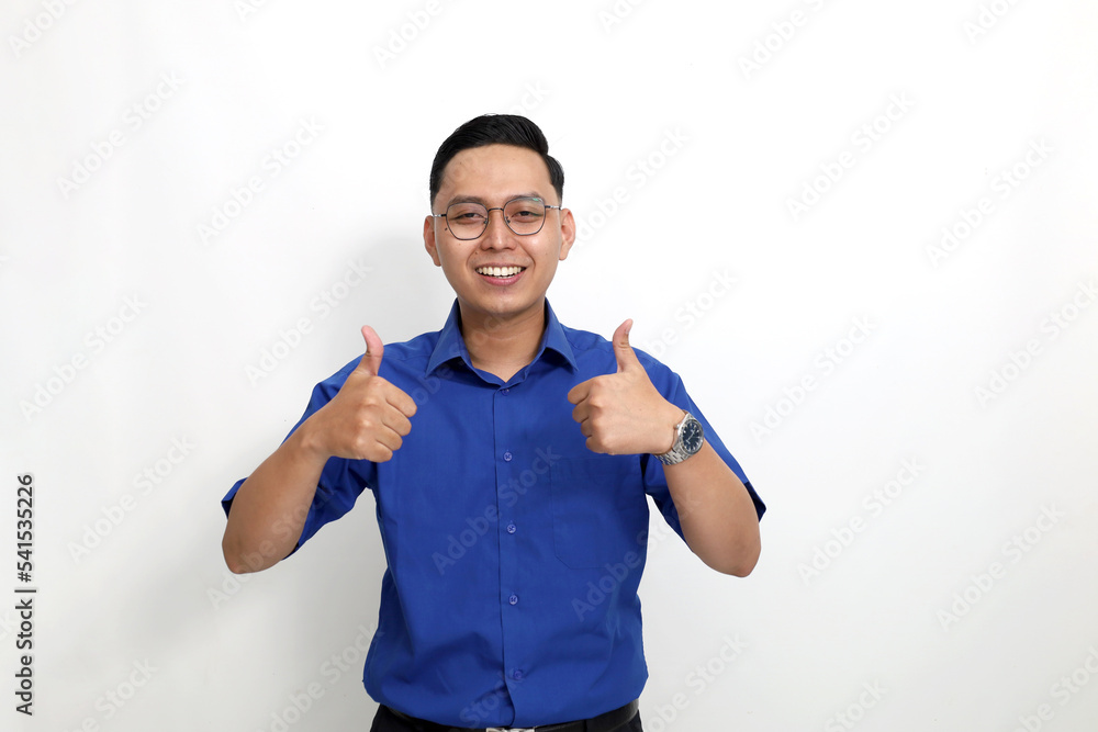 Happy young asian man standing while showing thumbs up. Isolated on white background