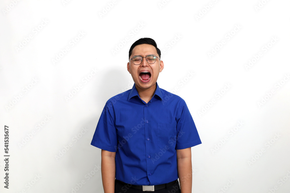 Fototapeta premium Frustrated young asian man standing while shouting or screaming. Isolated on white background