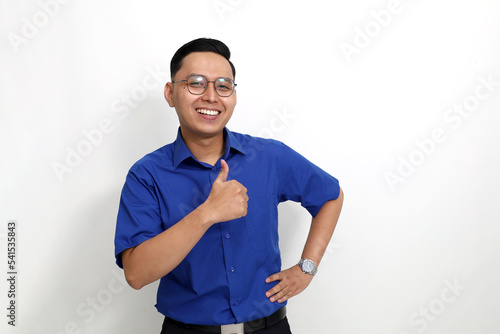 Happy young asian employee standing while showing thumbs up. Isolated on white background with copyspace
