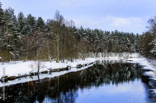 Winter forest landscape with a cold river