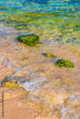 Stones rocks corals turquoise green blue water on beach Mexico.