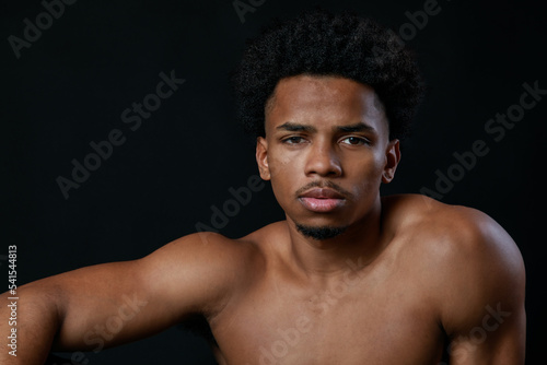 Young strong sportsman. Latin athlete portrait. Black background.