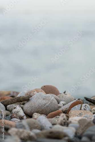 Close up image of the beach with sea in the distance with pebble stones