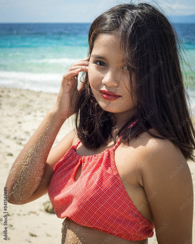 Obraz premium Beautiful Filipina in a red swimsuit posing at a beach in Capitancillo Island, Bogo city