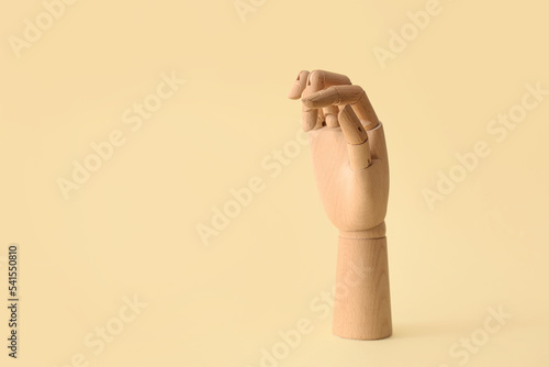 Wooden hand on yellow backg...