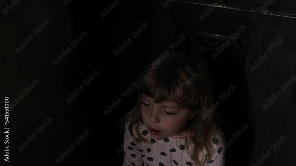 Scared girl with a doll in a dark room Scared girl with a doll in a dark room