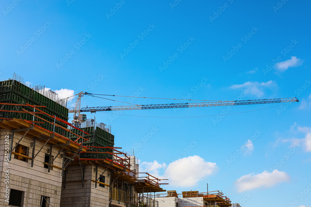 View of unfinished building and industrial crane View of unfinished building and industrial crane