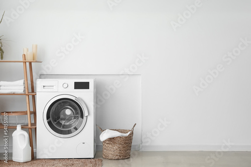 Cuadro en lienzo Interior of light laundry room with washing machine, basket and shelving unit