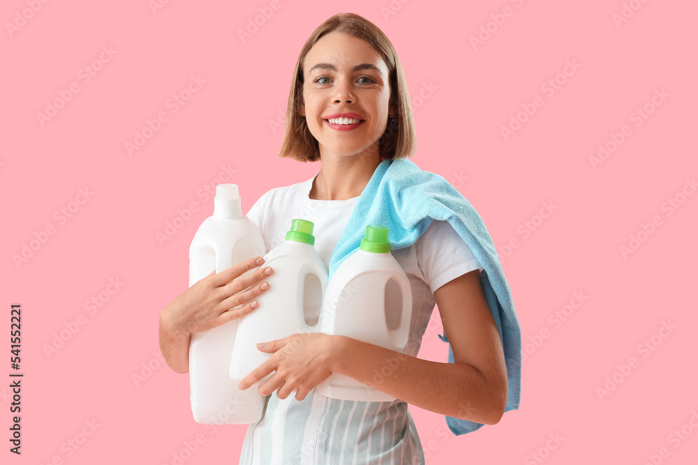 Pretty woman with bottles of detergent on pink background Pretty woman with bottles of detergent on pink background
