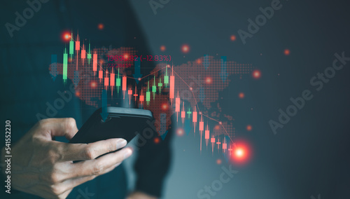 Businessman watching red graph on smartphone showing stock price slump. phone stock trading online. Investment concept and finance technology Funds for stock market investments and digital assets.