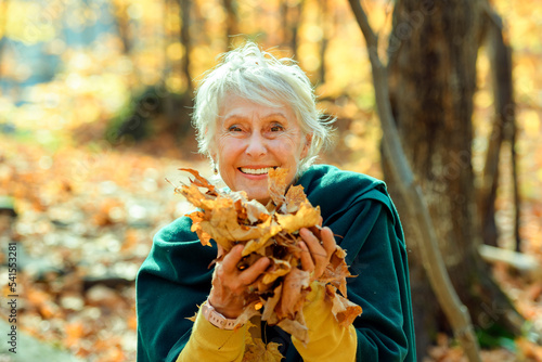 Happy elderly senior woman in an autumn park.