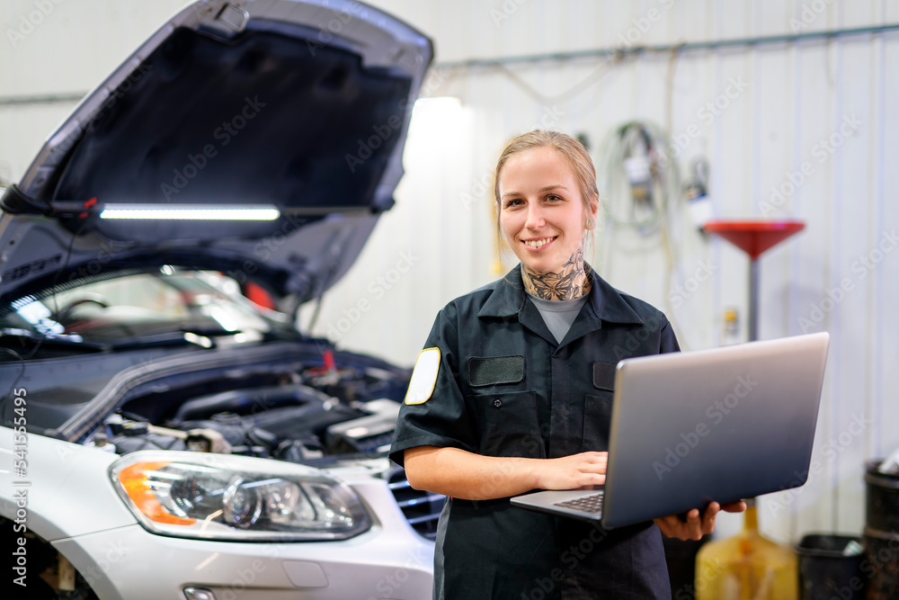 Handsome mechanic job woman in uniform working on car Handsome mechanic job woman in uniform working on car
