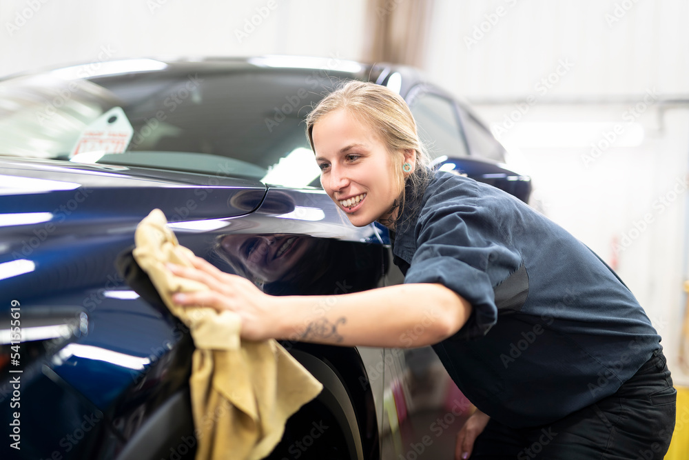 Woman at work cleaning automobile at car wash Woman at work cleaning automobile at car wash