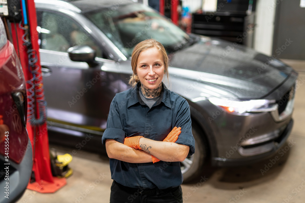 Handsome mechanic job woman in uniform working on car Handsome mechanic job woman in uniform working on car