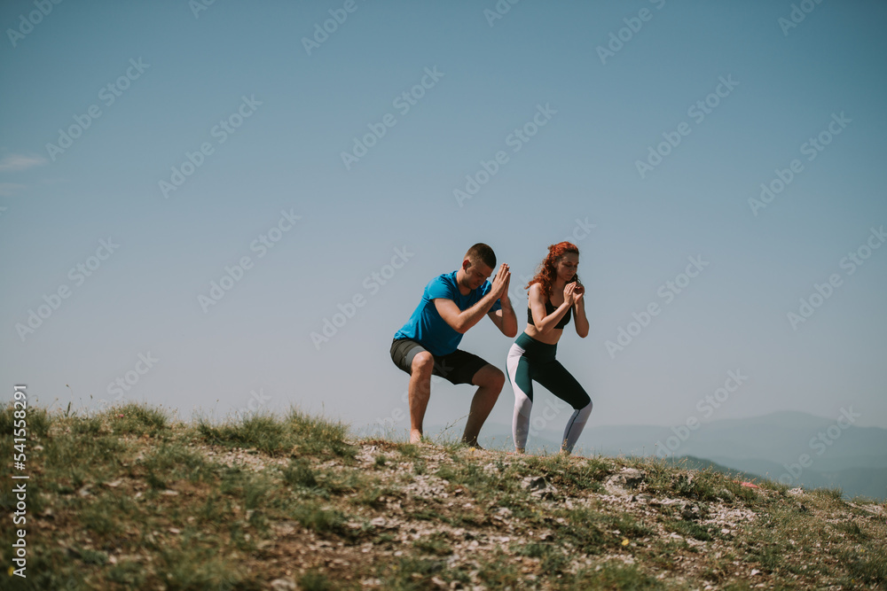 Yoga couple standing  on the top of the mountain