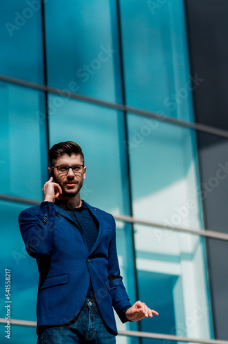 Business man walking while talking on mobile phone on his way to office