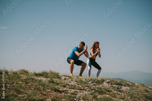 Yoga couple standing  on the top of the mountain