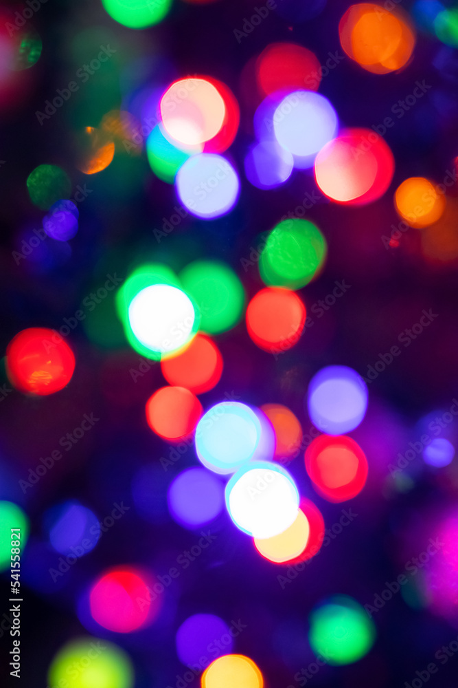Fototapeta premium Abstract background with colorful sparkling bokeh on a dark background. Holiday concept