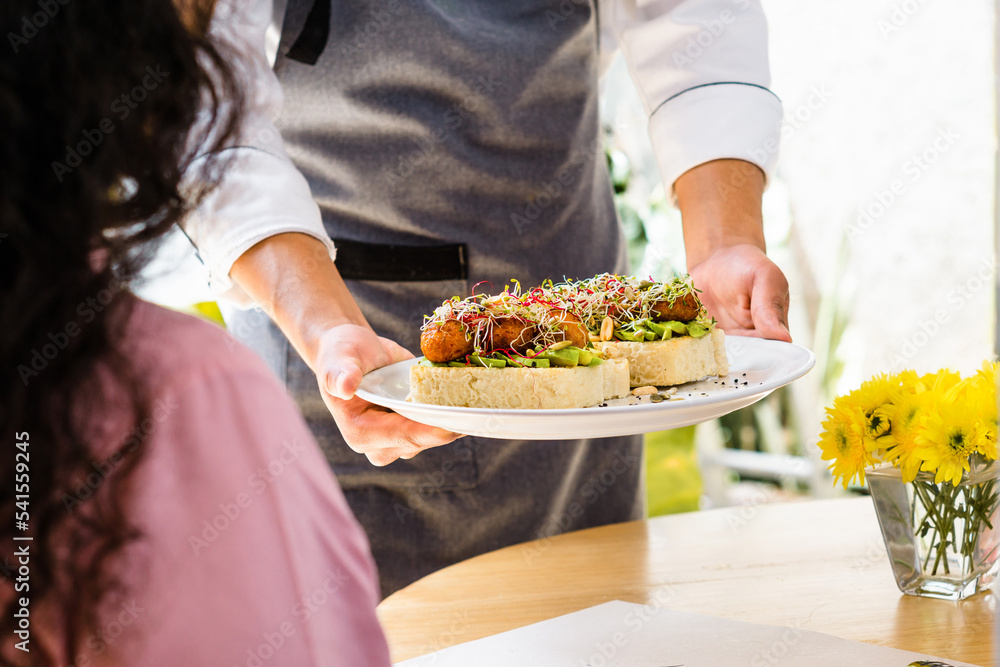 Restaurant customer placing the vegetarian food on the table.