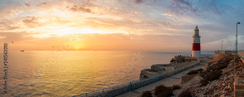 Europa Point Lighthouse with sea in background. Colorful Cloudy Sunrise Sky. Gibraltar, United Kingdom. Panorama