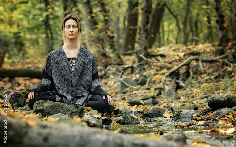 Woman meditating in the forest closeup