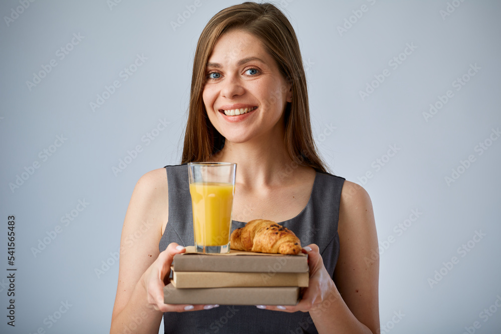 Woman teacher or student holding lunch with juice and croissant on books. isolated advertising portrait. Woman teacher or student holding lunch with juice and croissant on books. isolated advertising portrait.