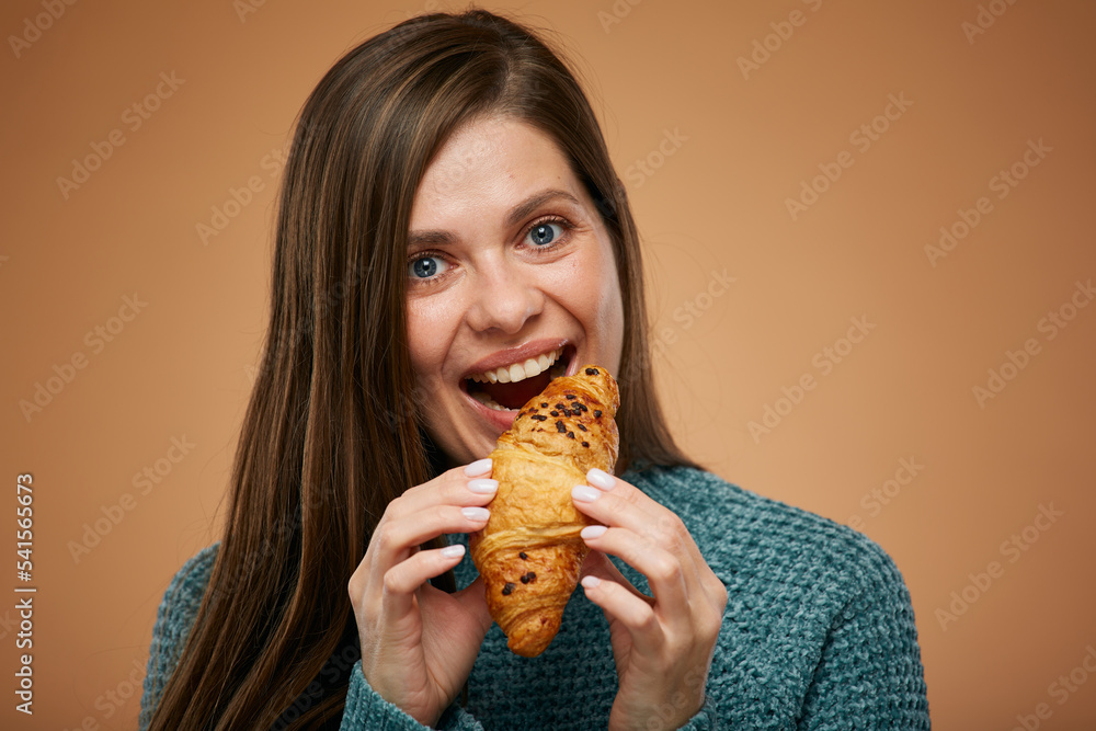 Young woman eating croissant. Advertising female studio portrait. Young woman eating croissant. Advertising female studio portrait.