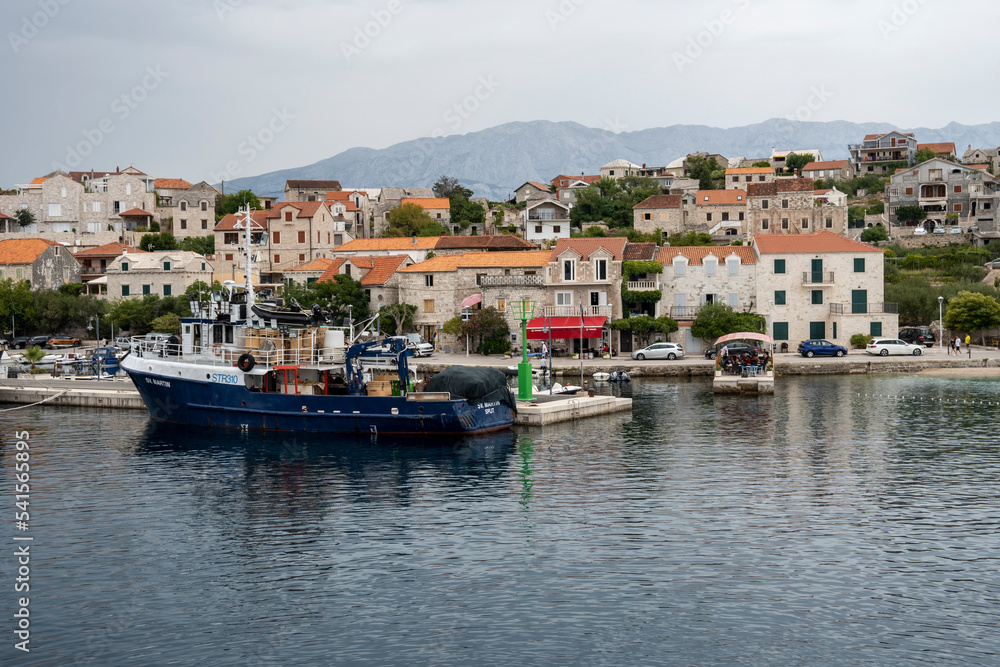 Sumartin town port on Brac island, Croatia with anchored fishing boats coloured in blue