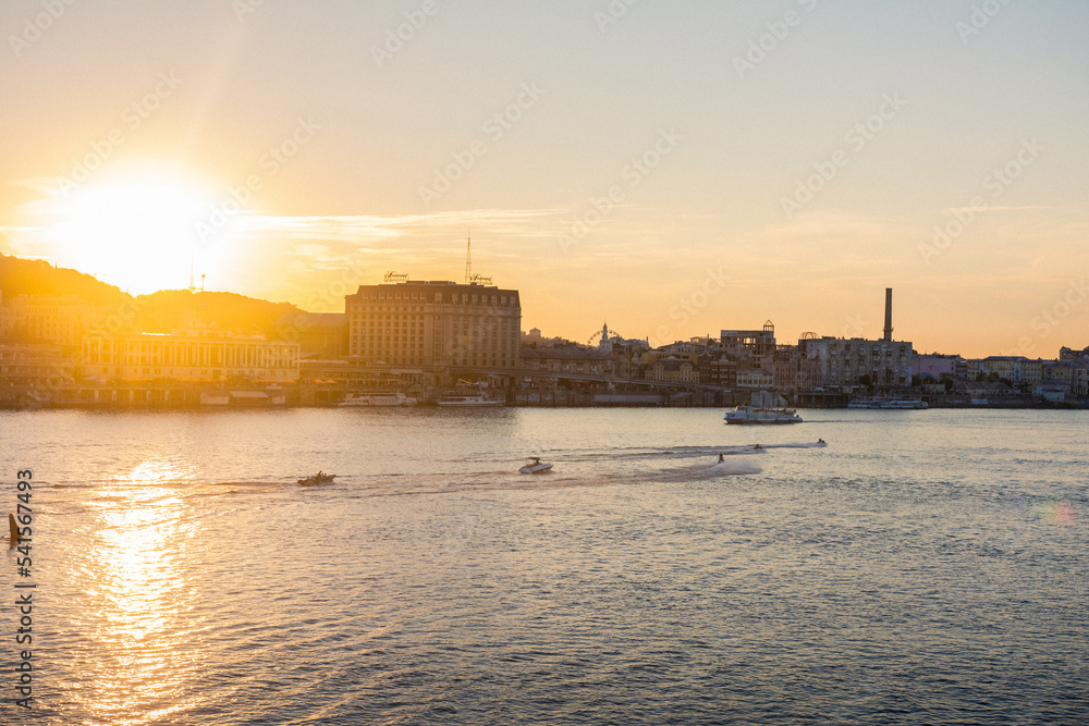 Sunset over the river on the background of the city