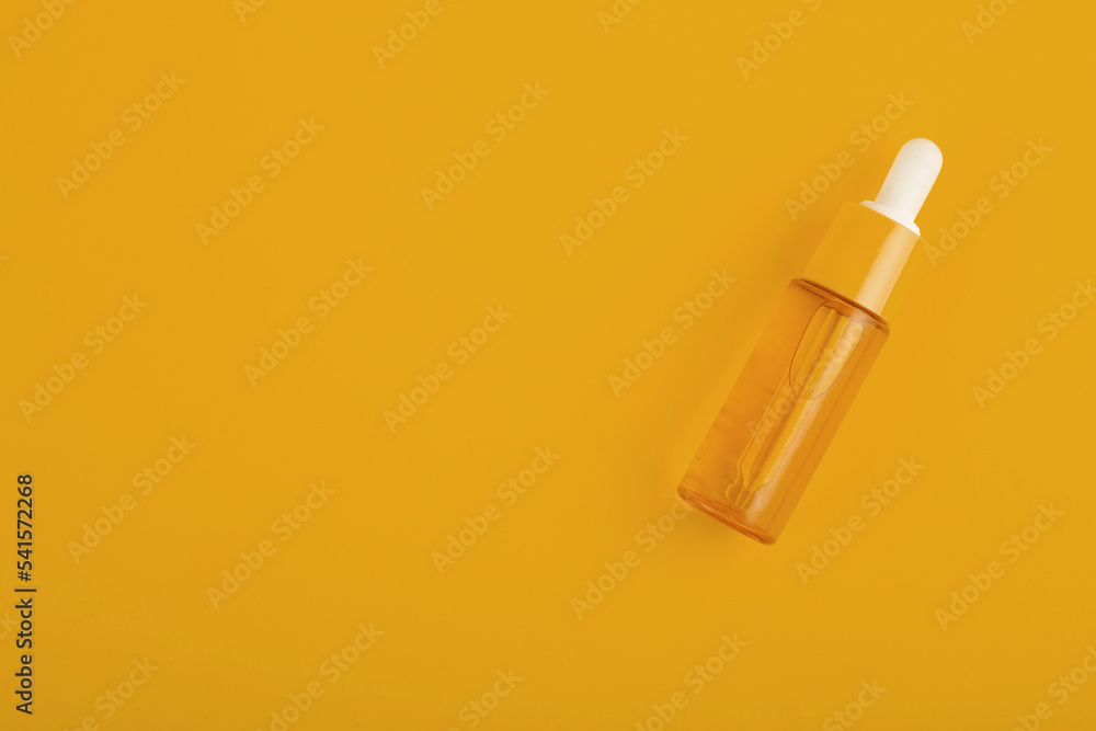 glass orange bottle with pipette with essential oil on a orange background top view. Aromatic cosmetic product for skin hair care Moisturizing beauty product with vitamin C close up glass orange bottle with pipette with essential oil on a orange background top view. Aromatic cosmetic product for skin hair care Moisturizing beauty product with vitamin C close up