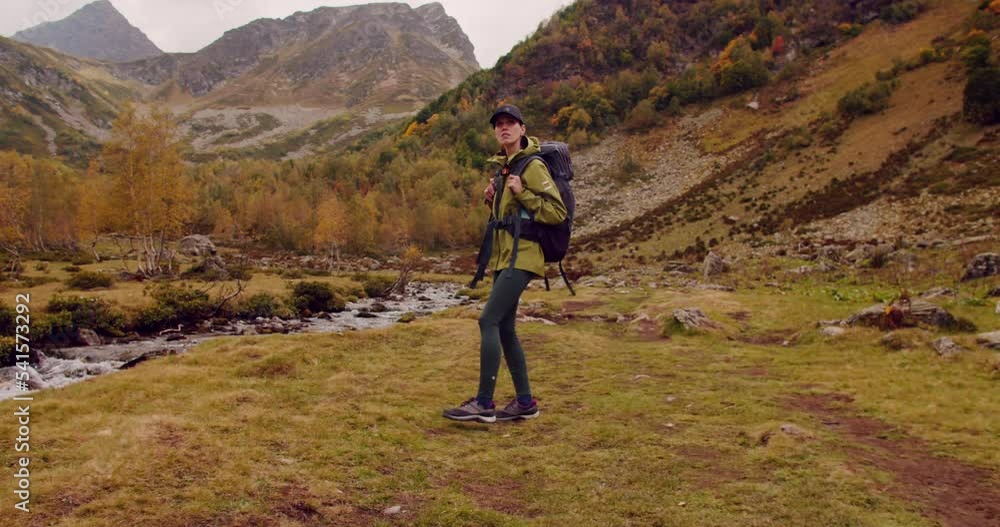 Young caucasian woman hiking in mountains with backpack, enjoying her adventure. Wied shot Young caucasian woman hiking in mountains with backpack, enjoying her adventure. Wied shot