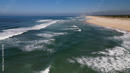 Side view of waves crashing on sandy beach