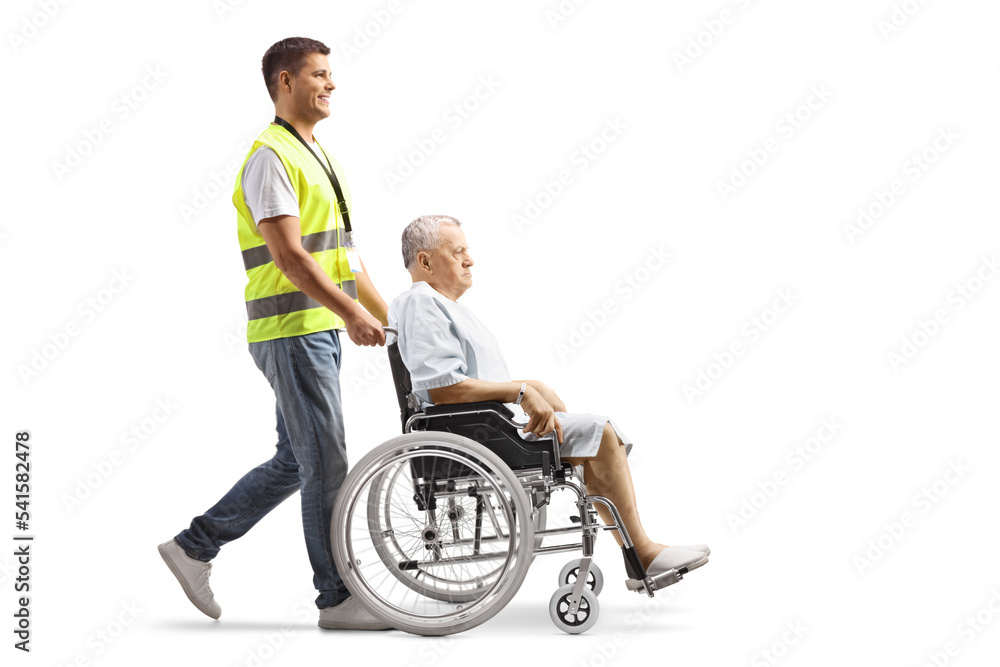 Full length profile shot of a hospital security worker pushing a patient in a wheelchair