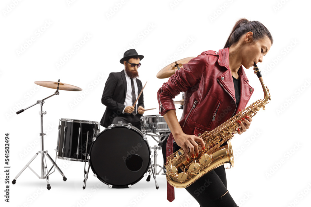 Naklejka premium Young female playing a saxophone and a man playing drums in the back